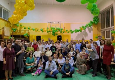 Wspólne zdjęcie uczestników Domu wraz z gośćmi na balu andrzejkowym w udekorowanej balonami sali gimnastycznej.